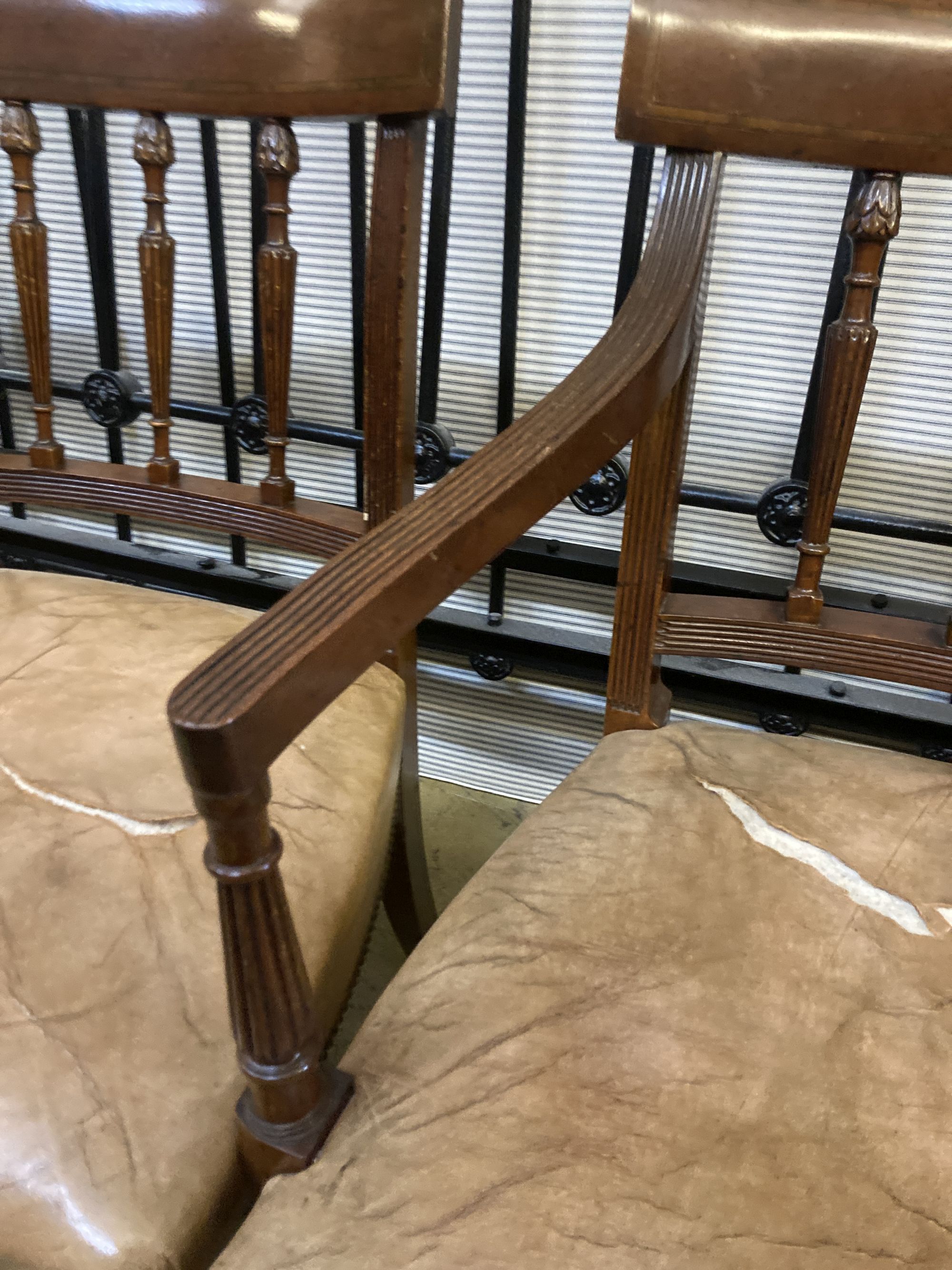 A set of eight George III style Sheraton design mahogany dining chairs, with leather stuff-over seats